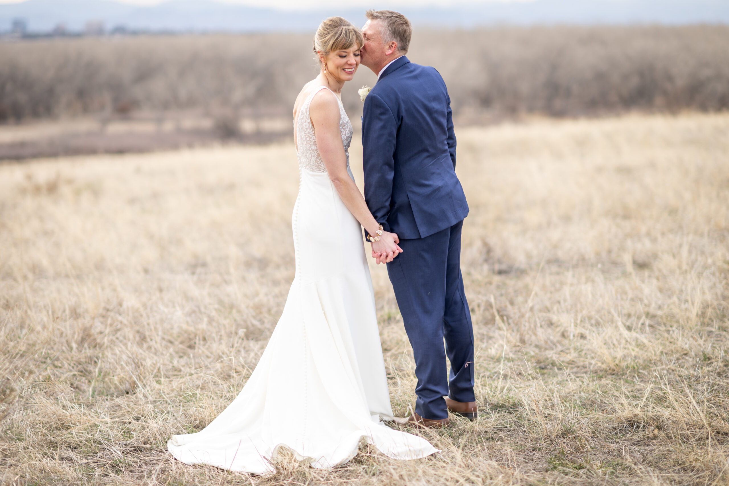 The bride and groom pose for couples photos at Cherry Creek State Park outside of Denver, Colorado.