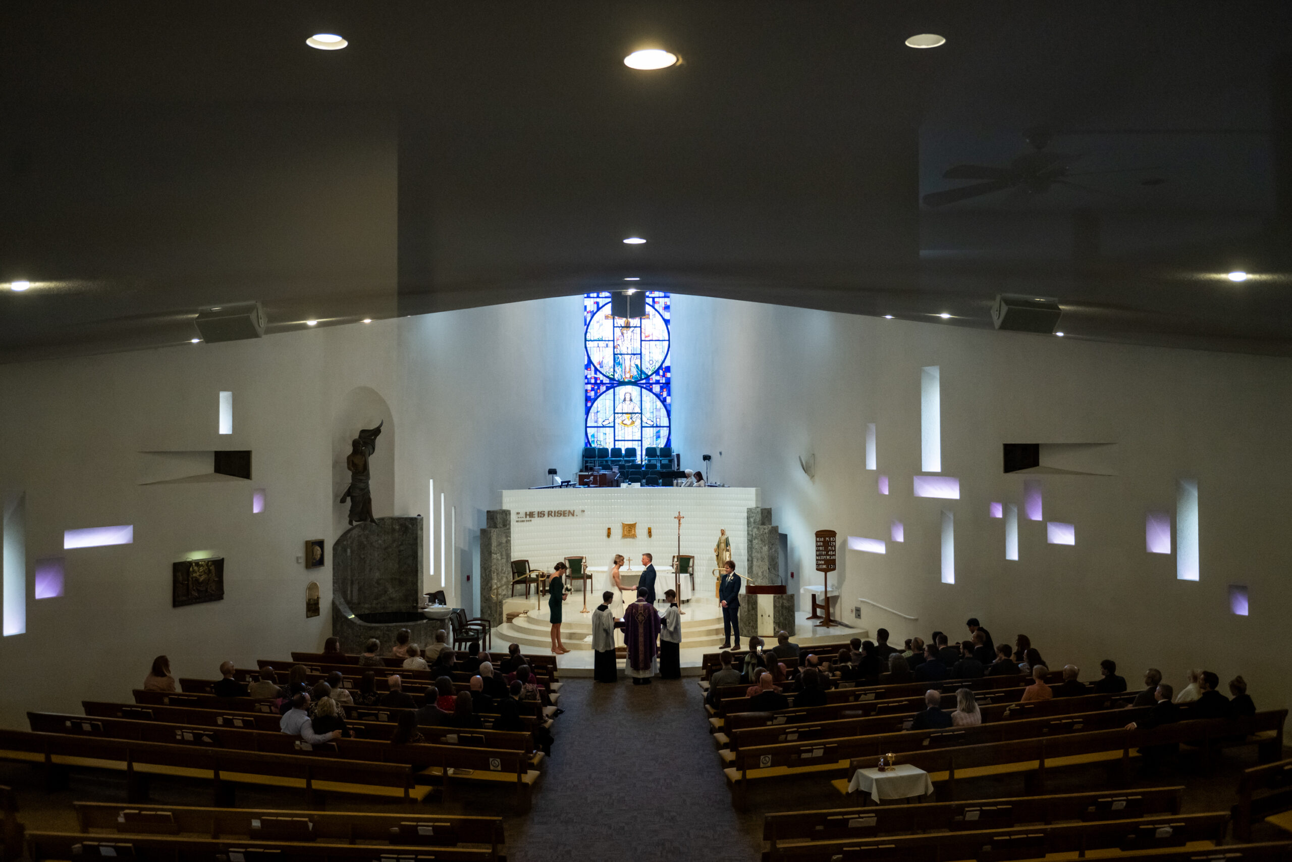 The bride and groom look on during their Risen Christ Church Denver wedding in Denver, Colorado.