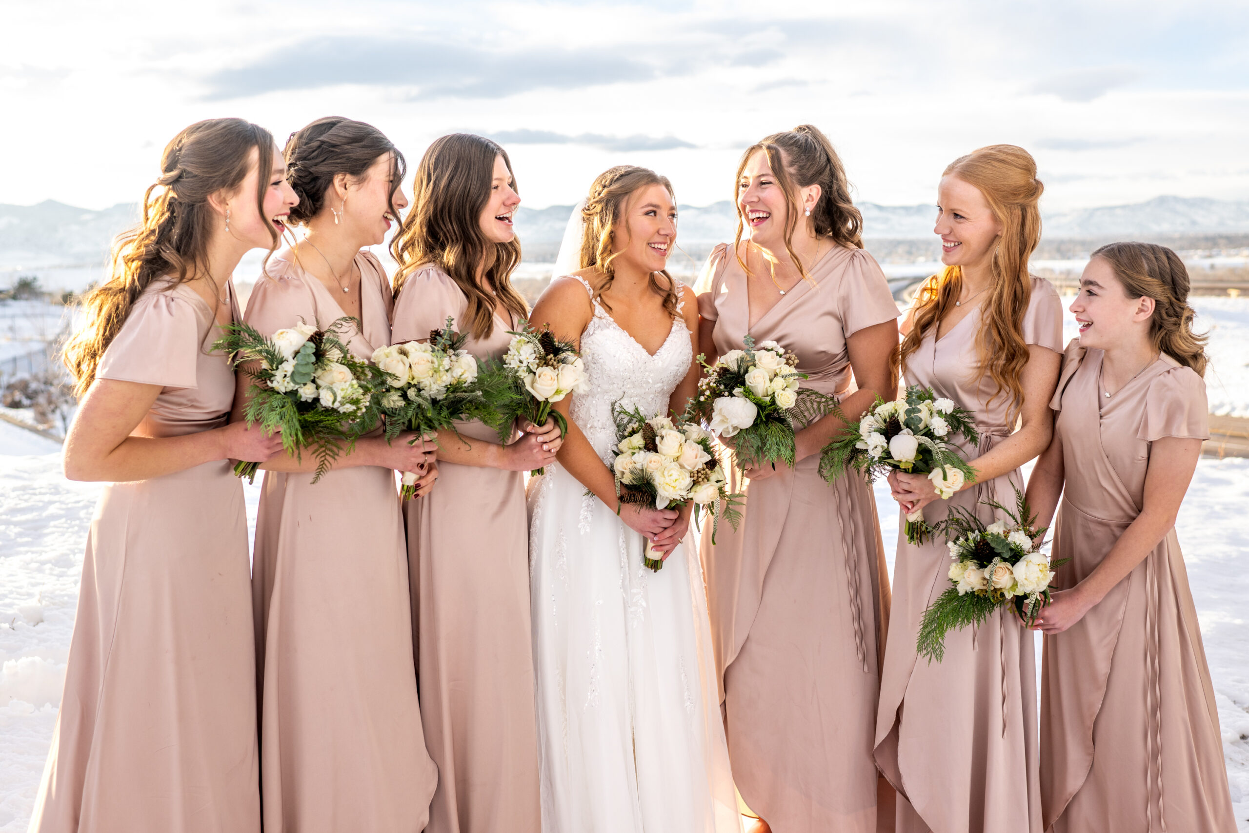 The bride poses with her bridesmaids at Fly'n B Park in Littleton, Colorado, during their wedding at Ashley Ridge by Wedgewood Weddings.