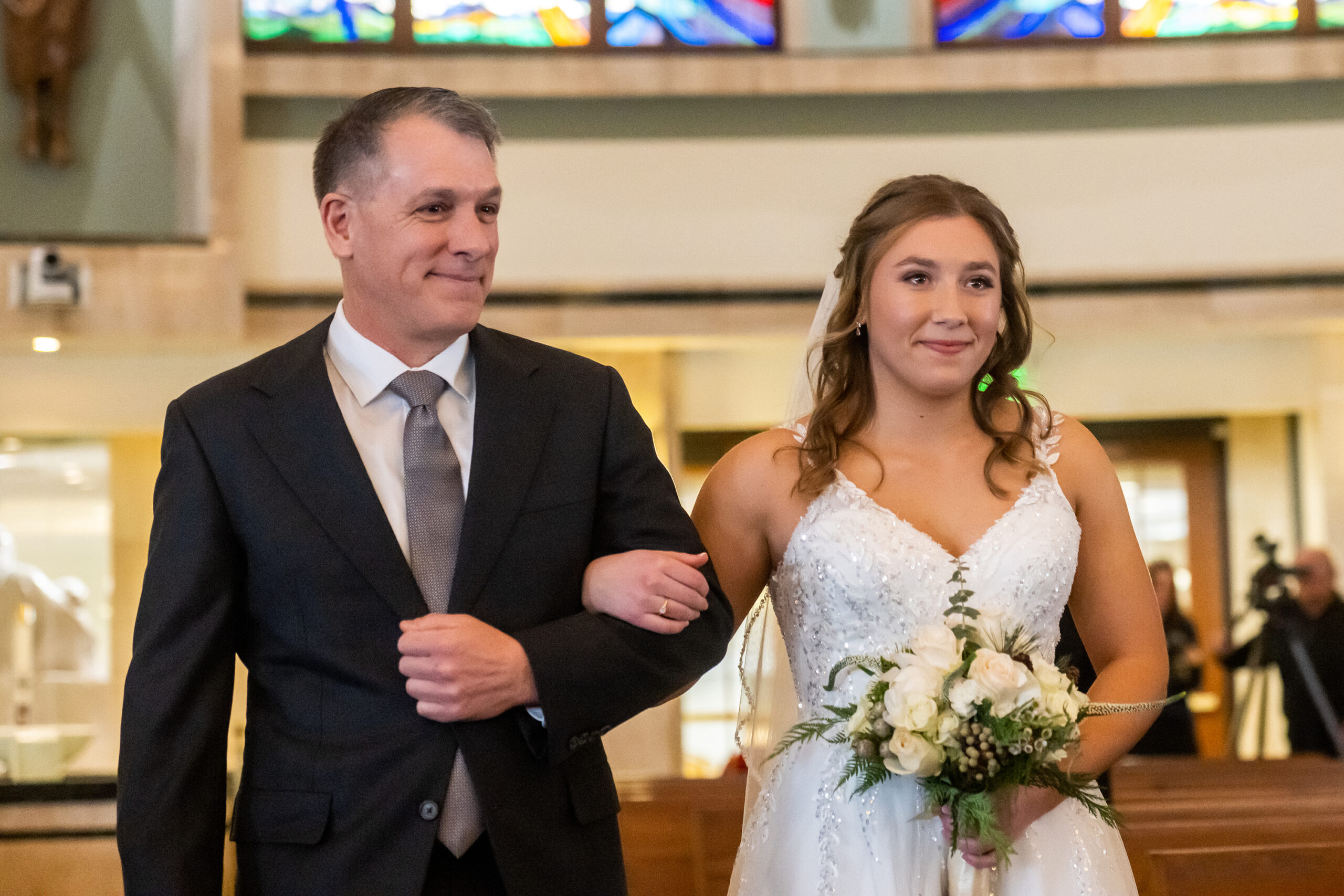 Jaime walks with her father down the aisle during her St. Thomas More Catholic Church wedding in Centennial, Colorado.