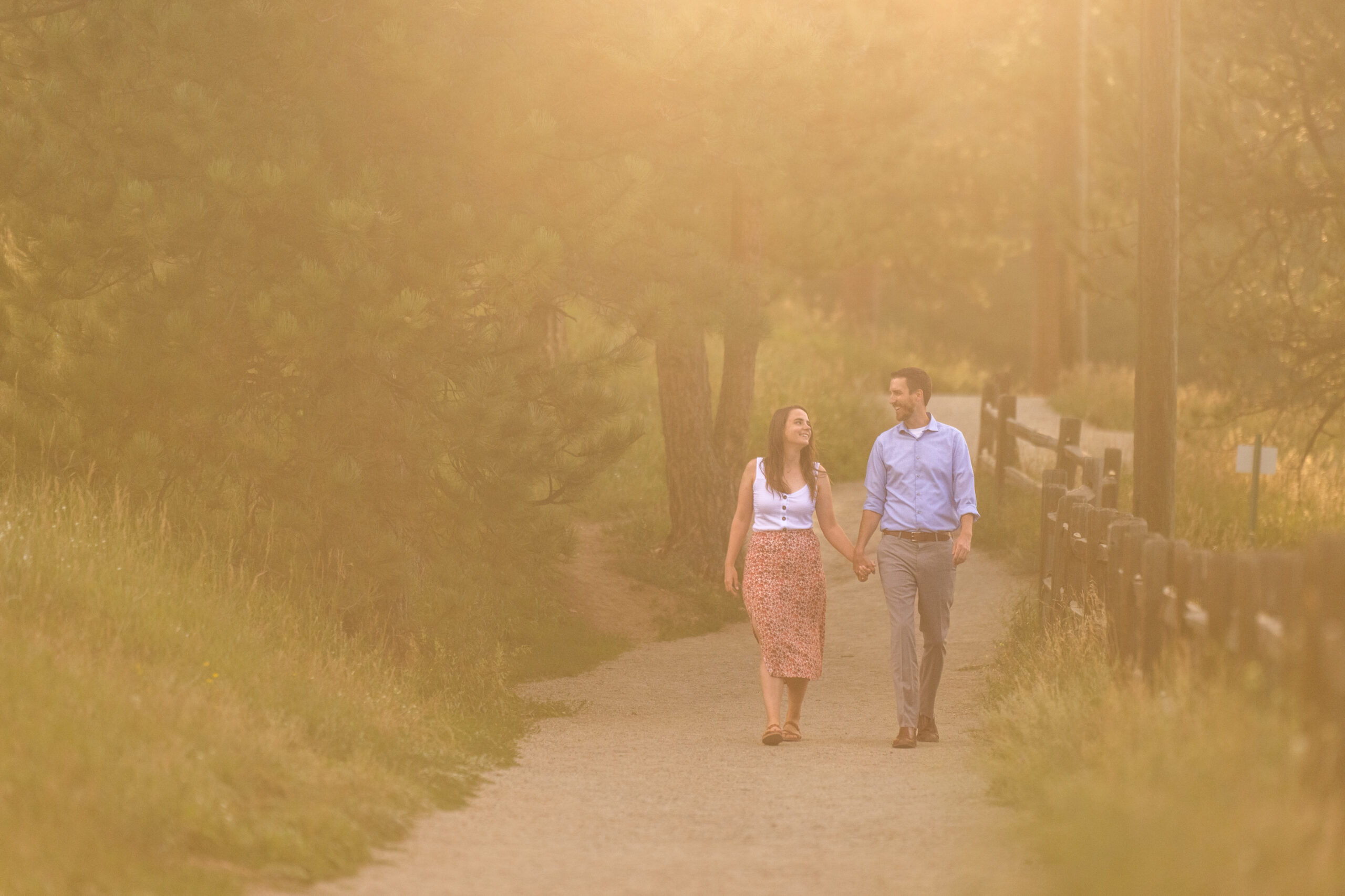 Alice and Joe hold hands during an engagement photo shoot at Evergreen Lake in Evergreen, Colorado.