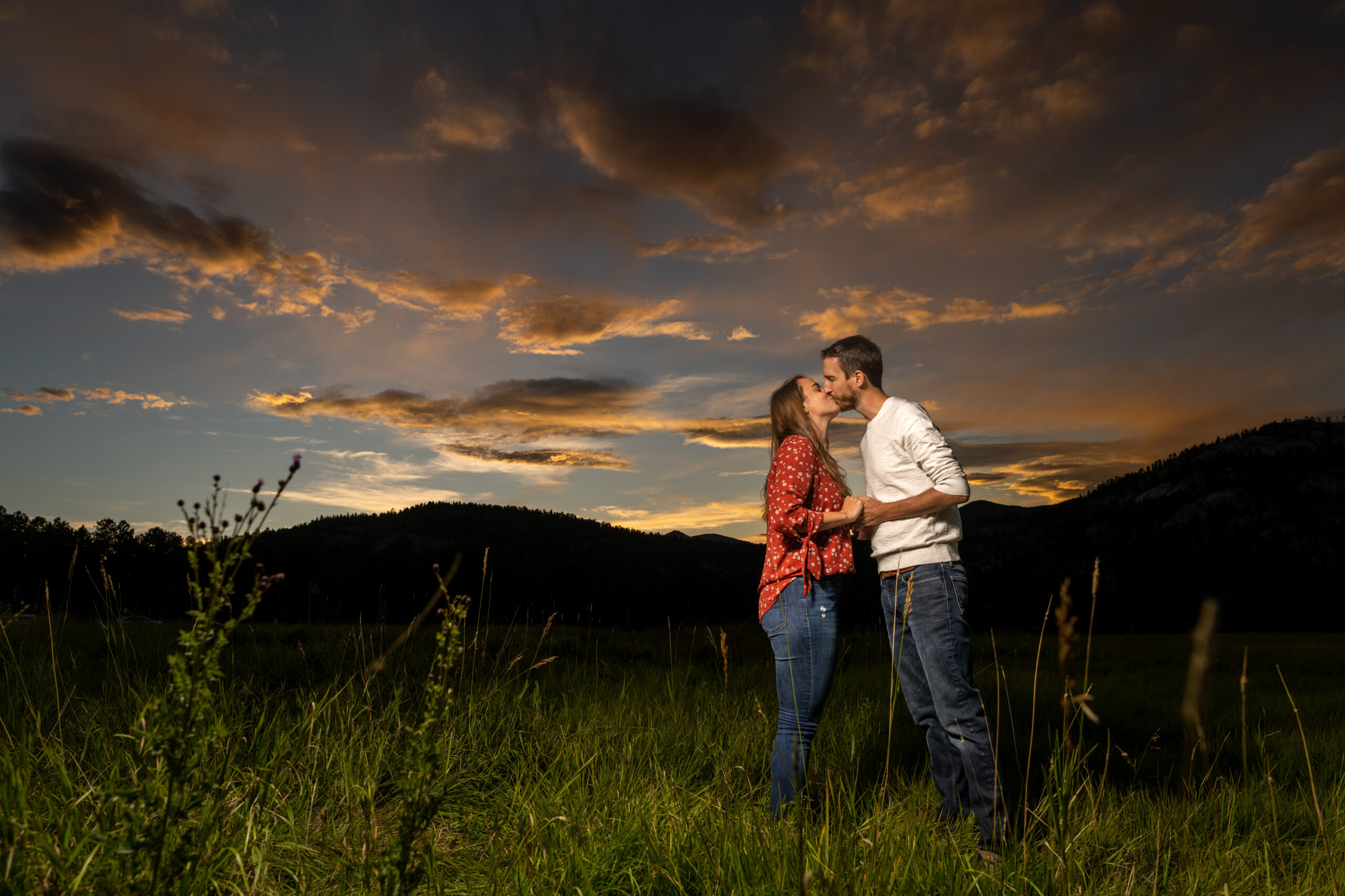 Alice and Joe kiss during an engagement photo shoot at Three Sisters Park in Evergreen, Colorado.