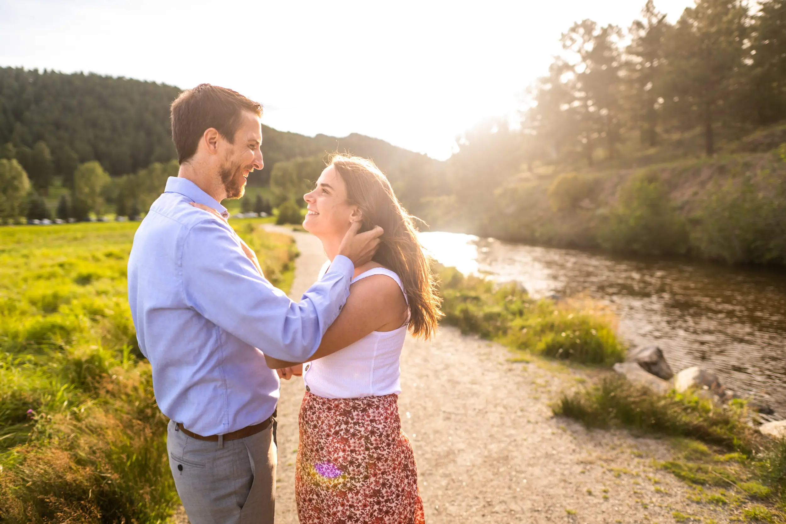 Alice and Joe stroke hair during an engagement photo shoot at Evergreen Lake in Evergreen, Colorado.