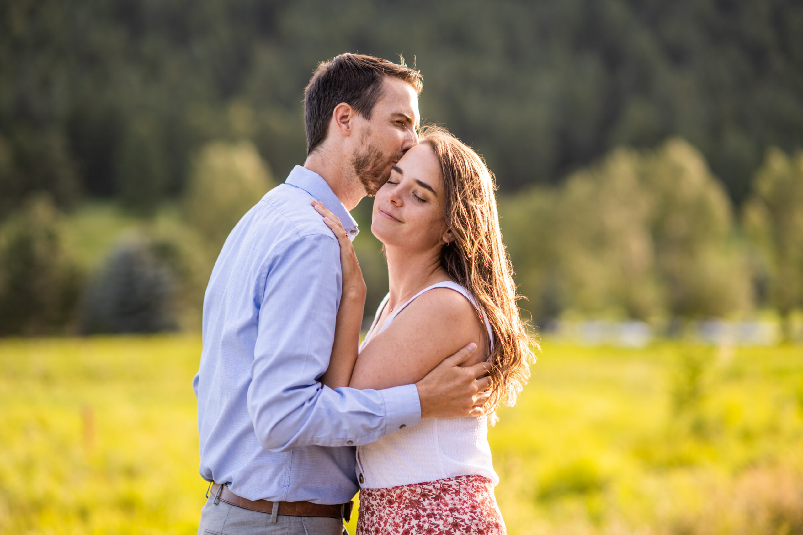 Alice and Joe hug during an engagement photo shoot at Evergreen Lake in Evergreen, Colorado.