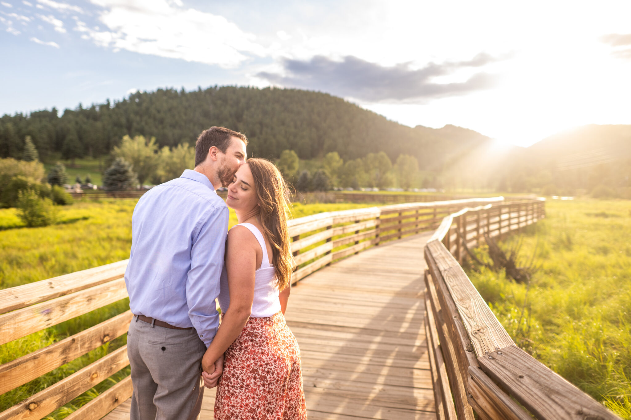 Alice and Joe kiss during an engagement photo shoot at Evergreen Lake in Evergreen, Colorado.