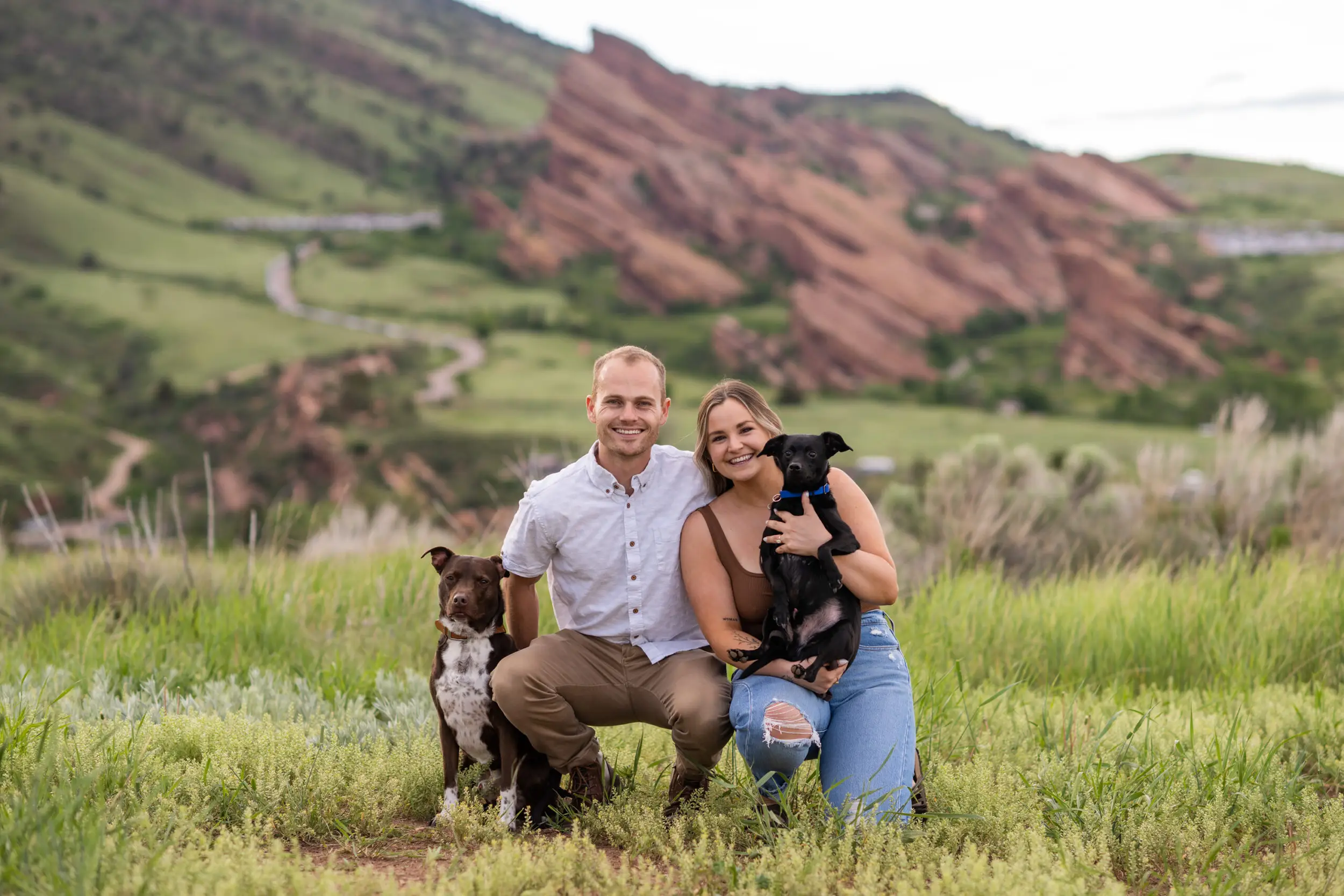 Ryan and Elizabeth pose with their dogs during surprise proposal and engagement photos at Mt. Falcon Park East Trailhead near Denver, Colorado.