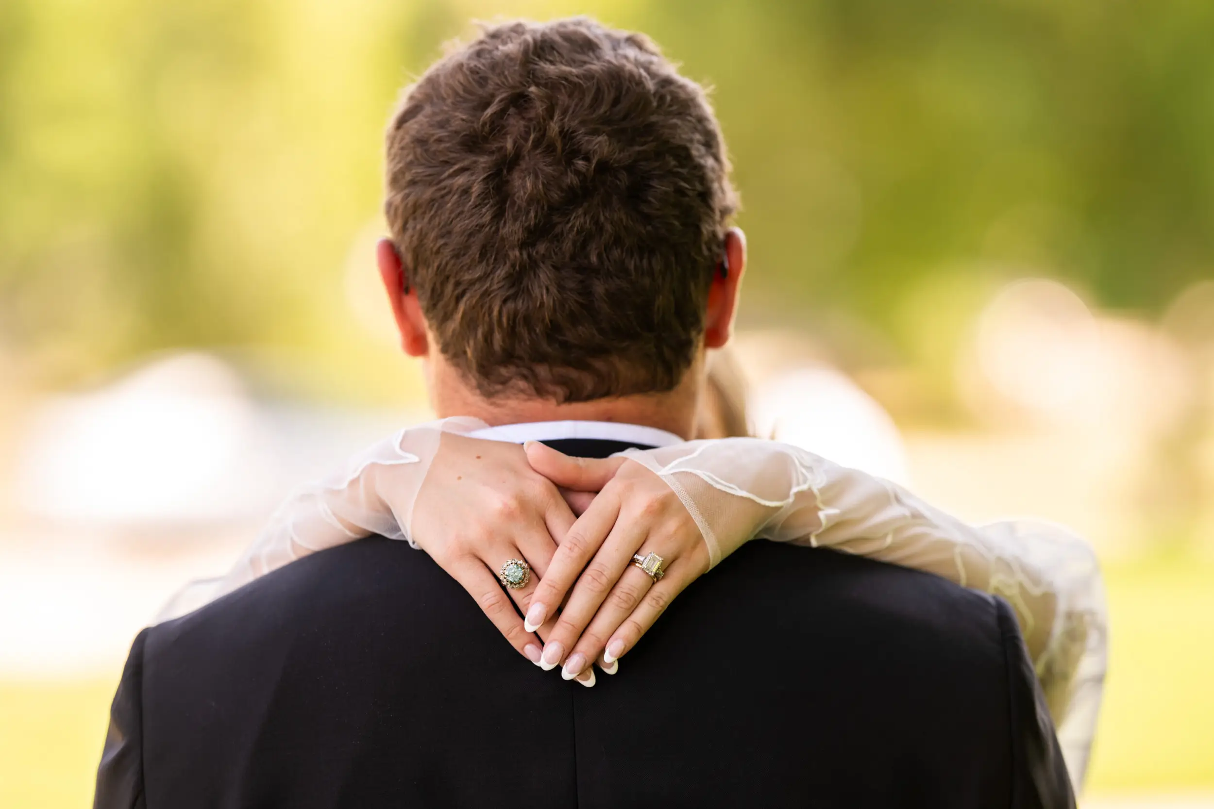 A bride drapes her hands around the neck of her groom in City Park in Denver, Colorado, after their wedding ceremony.