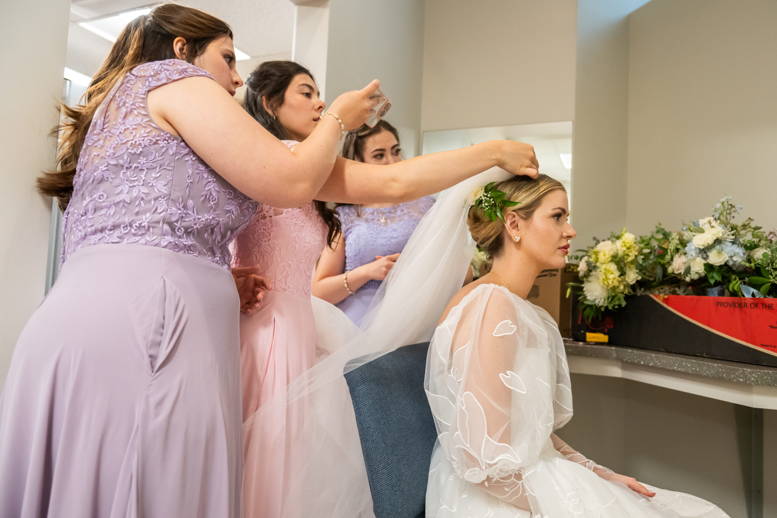 Bridesmaids put the vail on the bride for a wedding at the Cathedral Basilica of the Immaculate Conception in Denver, Colorado.