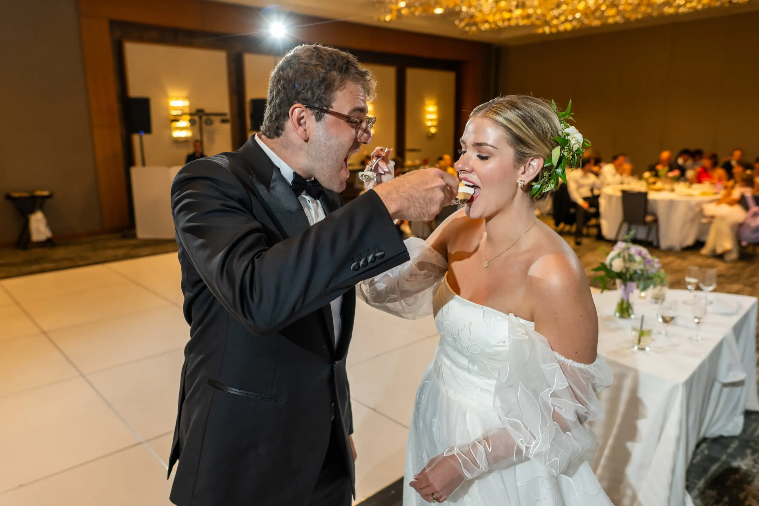 A bride and groom feed each other cake at their wedding at the Pinnacle Club at the Grand Hyatt in Denver, Colorado.