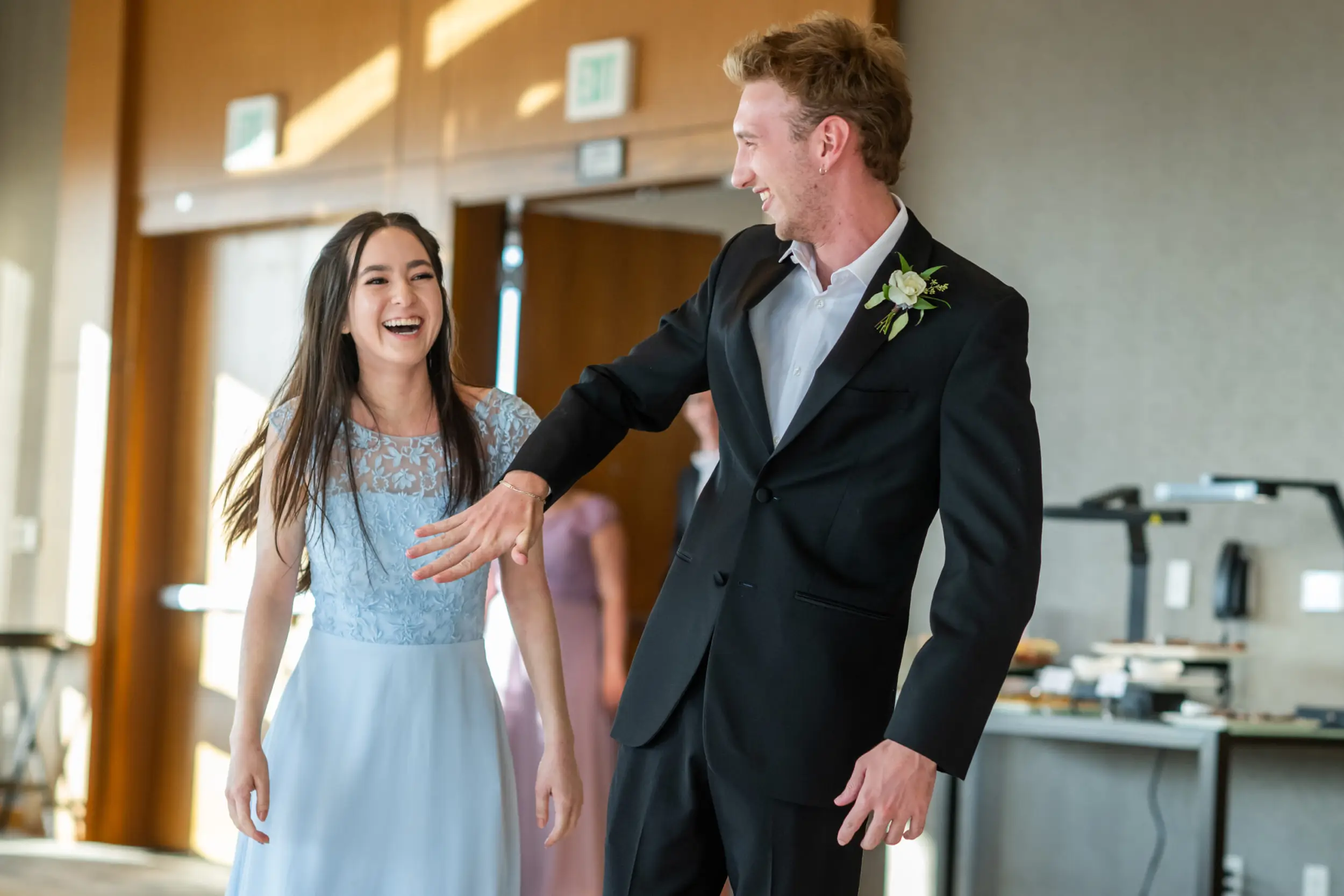 A bridesmaid and groomsman react after being introduced at a wedding at the Pinnacle Club at the Grand Hyatt in Denver, Colorado.