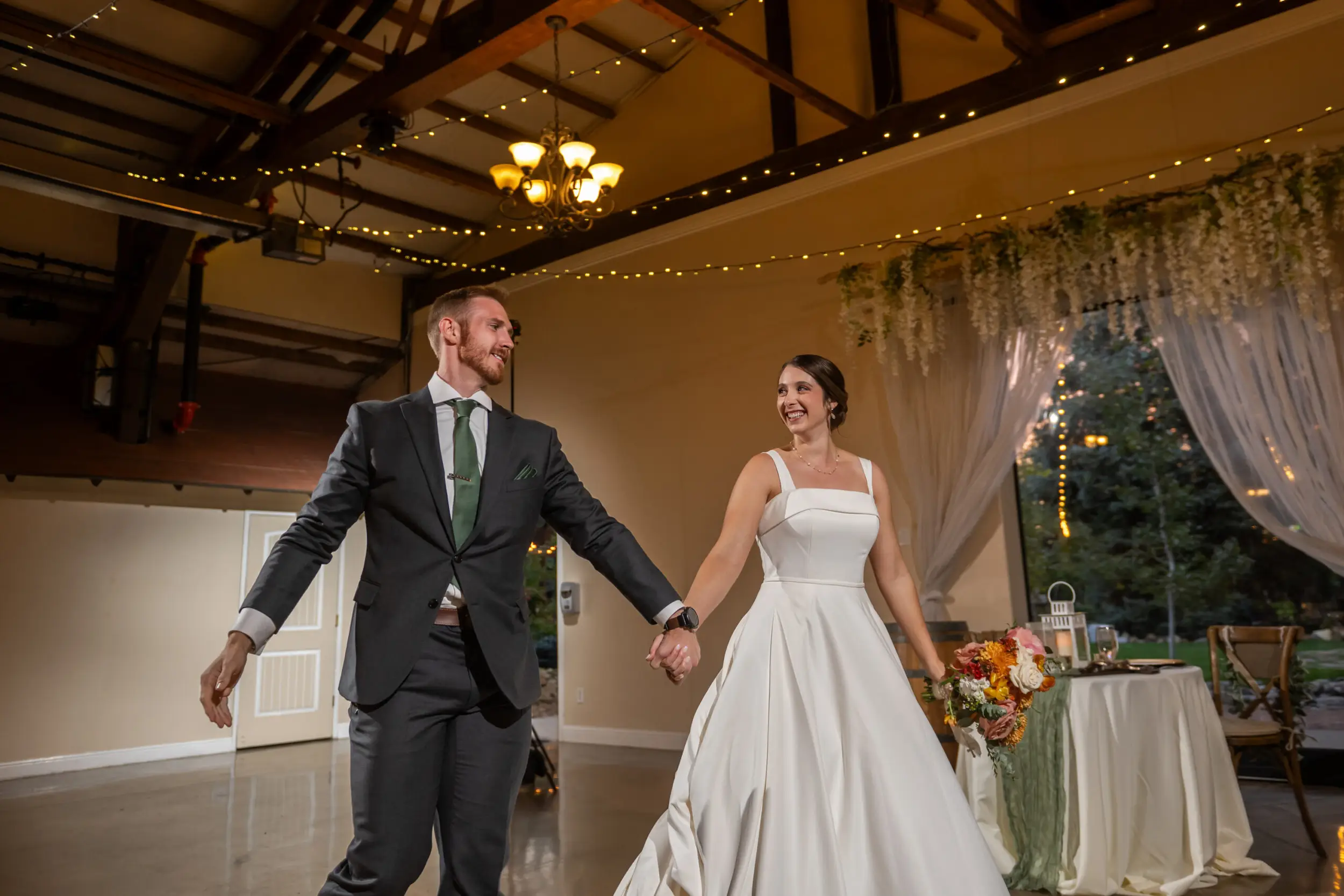 The bride and groom enter during their wedding reception at the Church Ranch Event Center in Westminster, Colorado.
