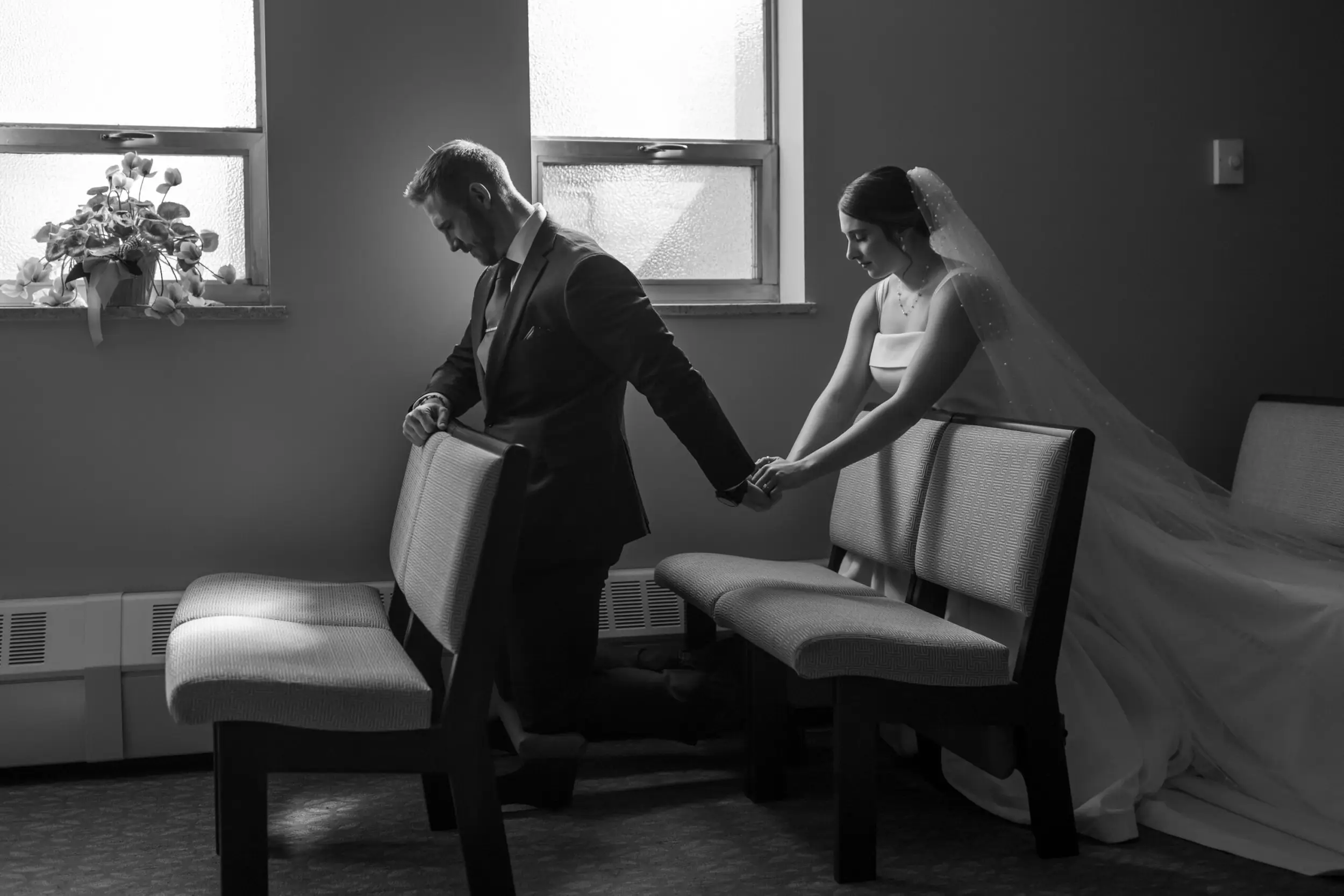 The bride and groom pray before their wedding Mass at Our Lady of Lourdes Catholic Church in Denver, Colorado.