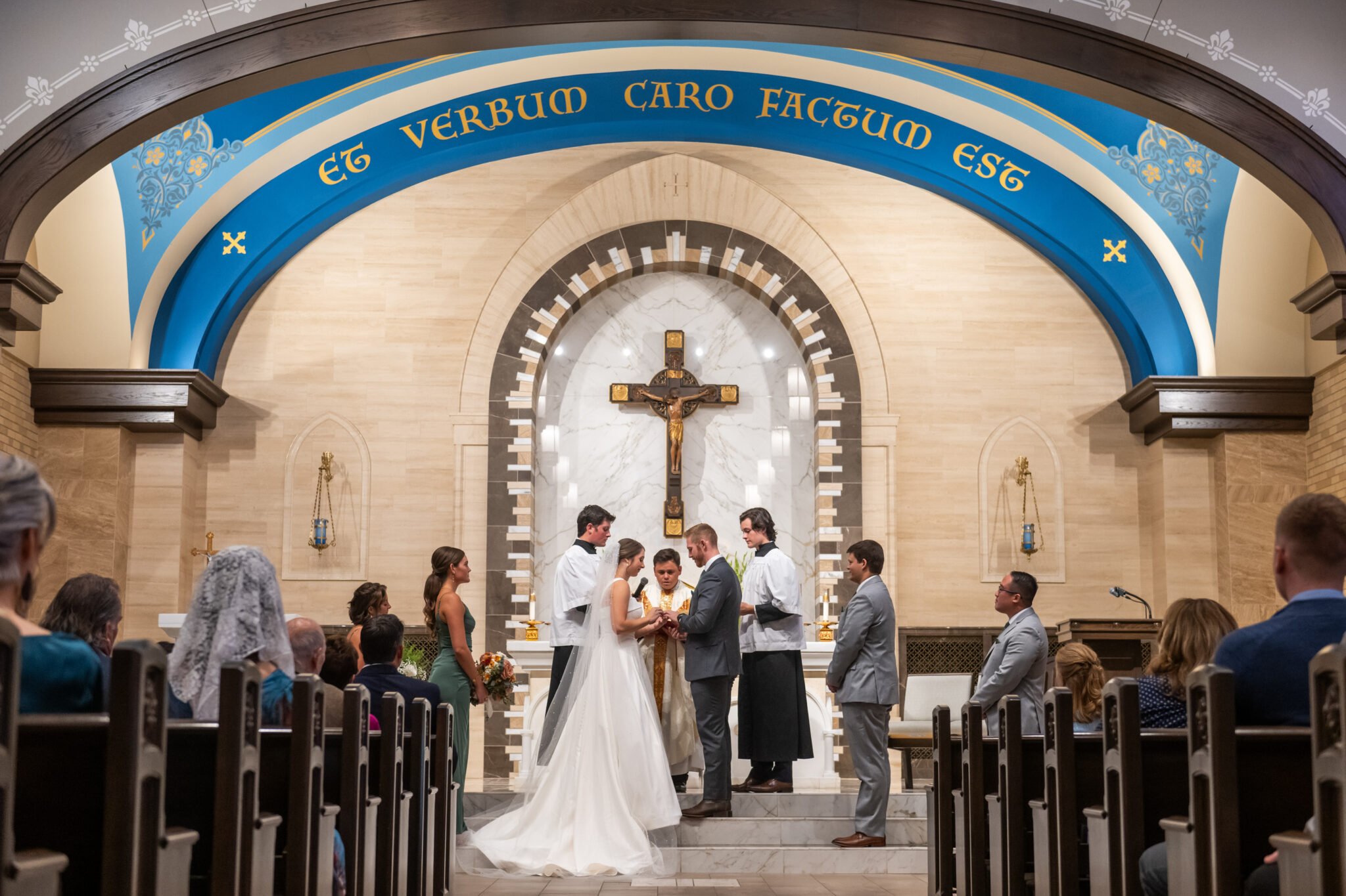 The bride and groom exchange vows during a nuptial wedding Mass at Our Lady of Lourdes Catholic Church in Denver, Colorado.