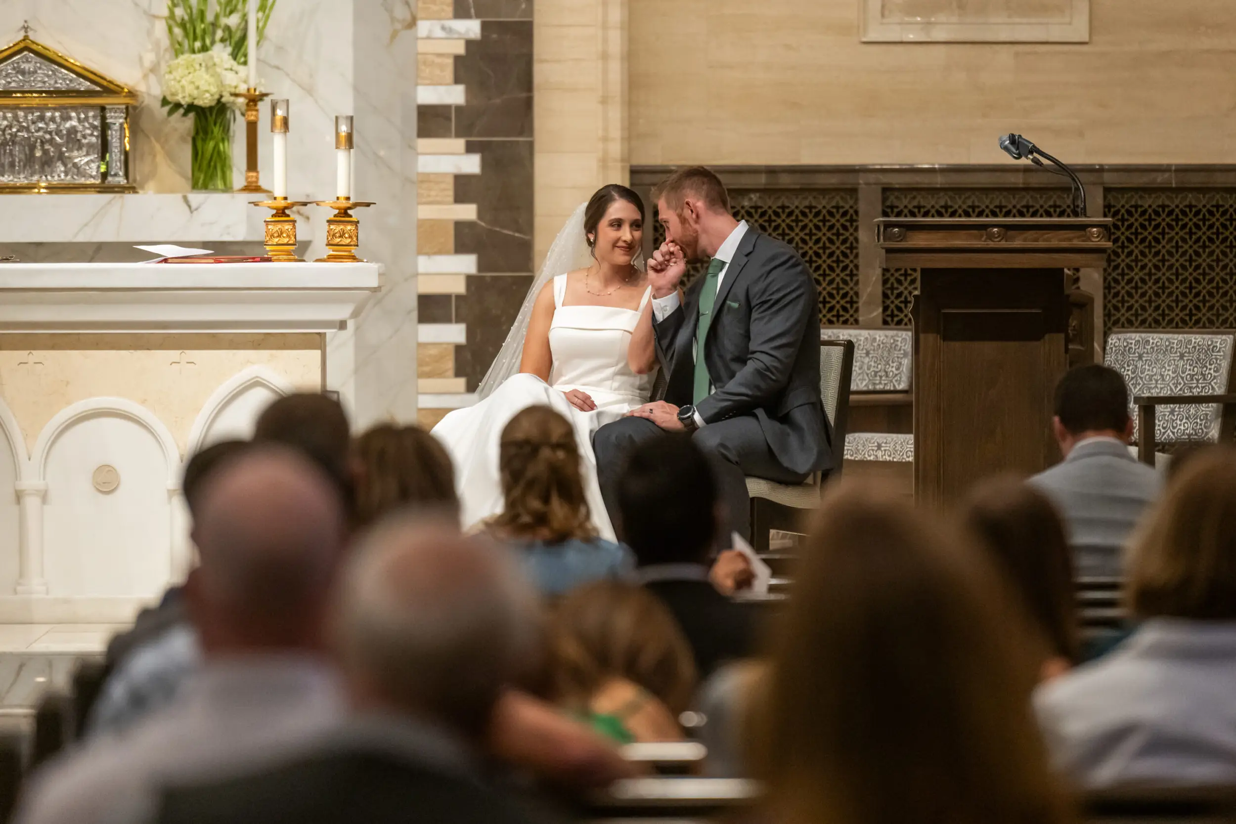 A groom kisses his bride's hand during a wedding Mass at Our Lady of Lourdes Catholic Church in Denver, Colorado.