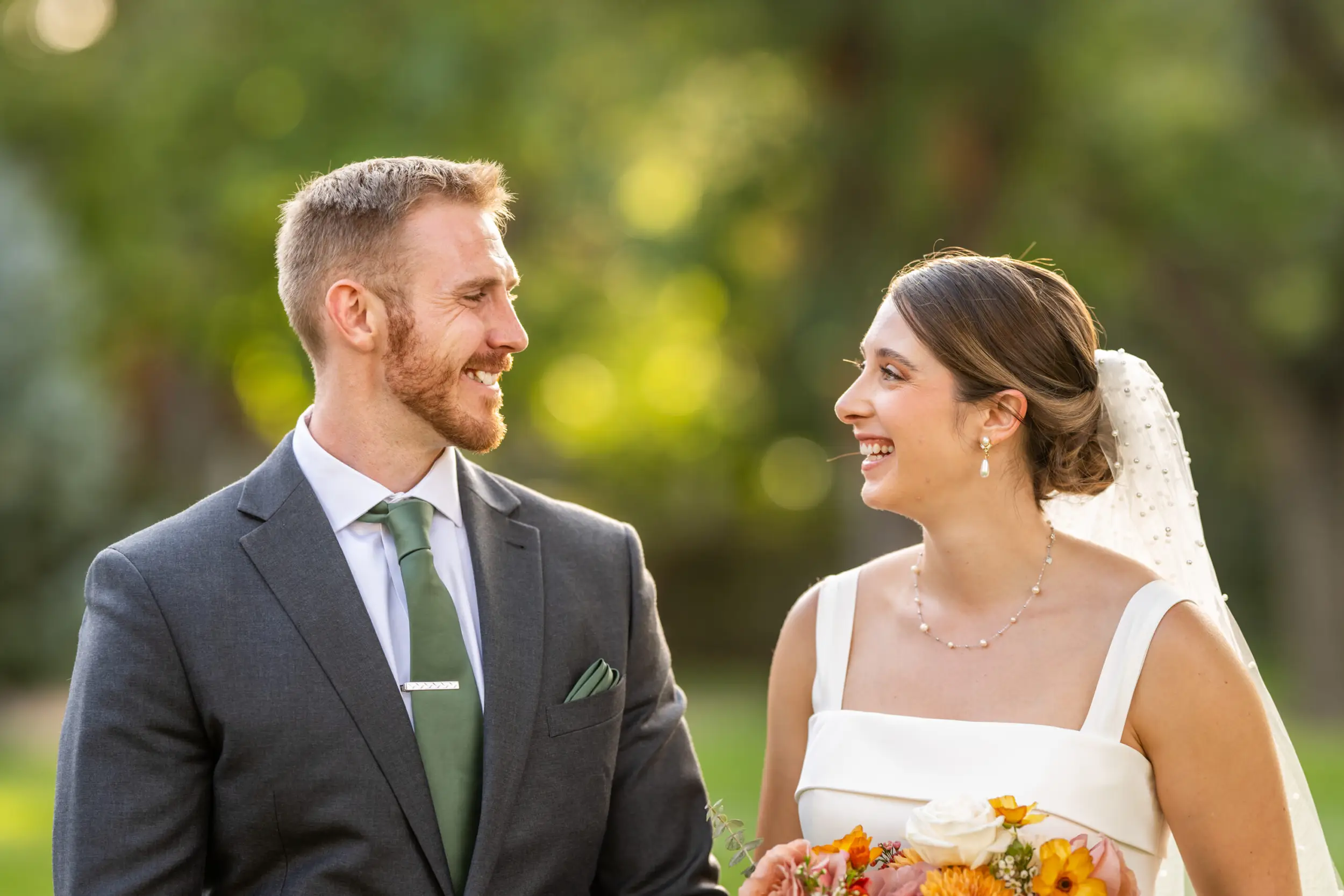 A bride and groom look at each other and smile after their wedding at Our Lady of Lourdes Catholic Church in Denver, Colorado.