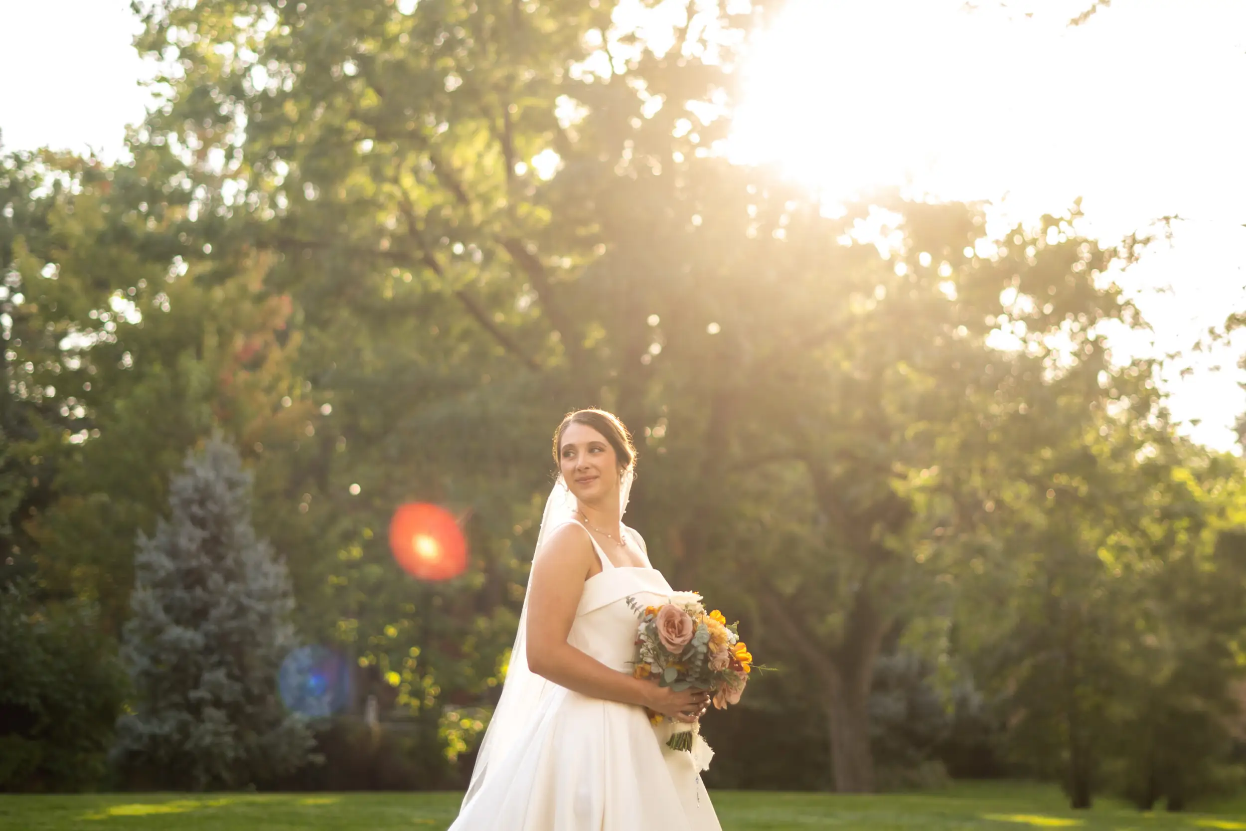A bride looks away from the camera in a pose with her bouquet after her wedding at Our Lady of Lourdes Catholic Church in Denver, Colorado.