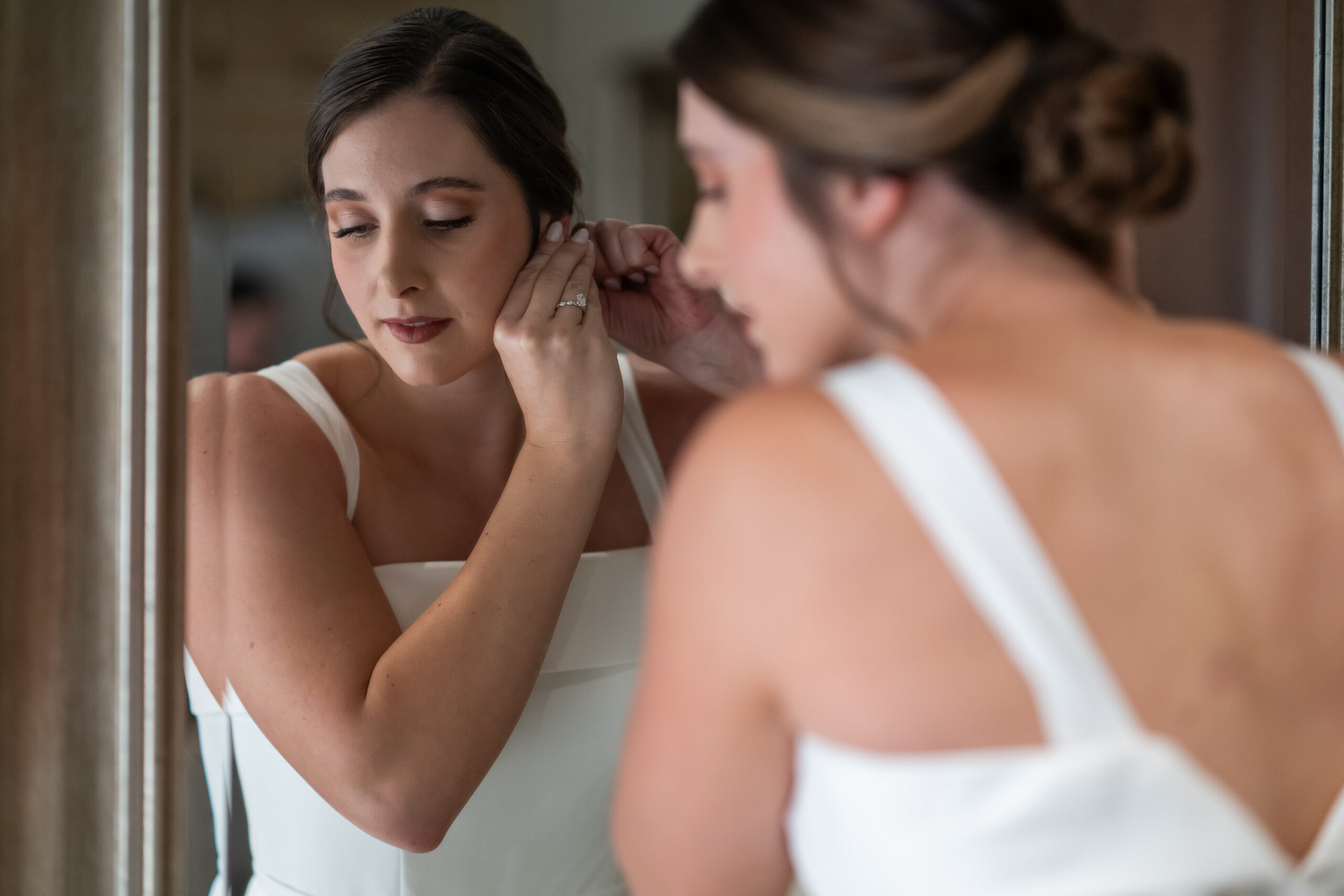 The bride pins on her earrings before her wedding Mass at Our Lady of Lourdes Catholic Church in Denver, Colorado.