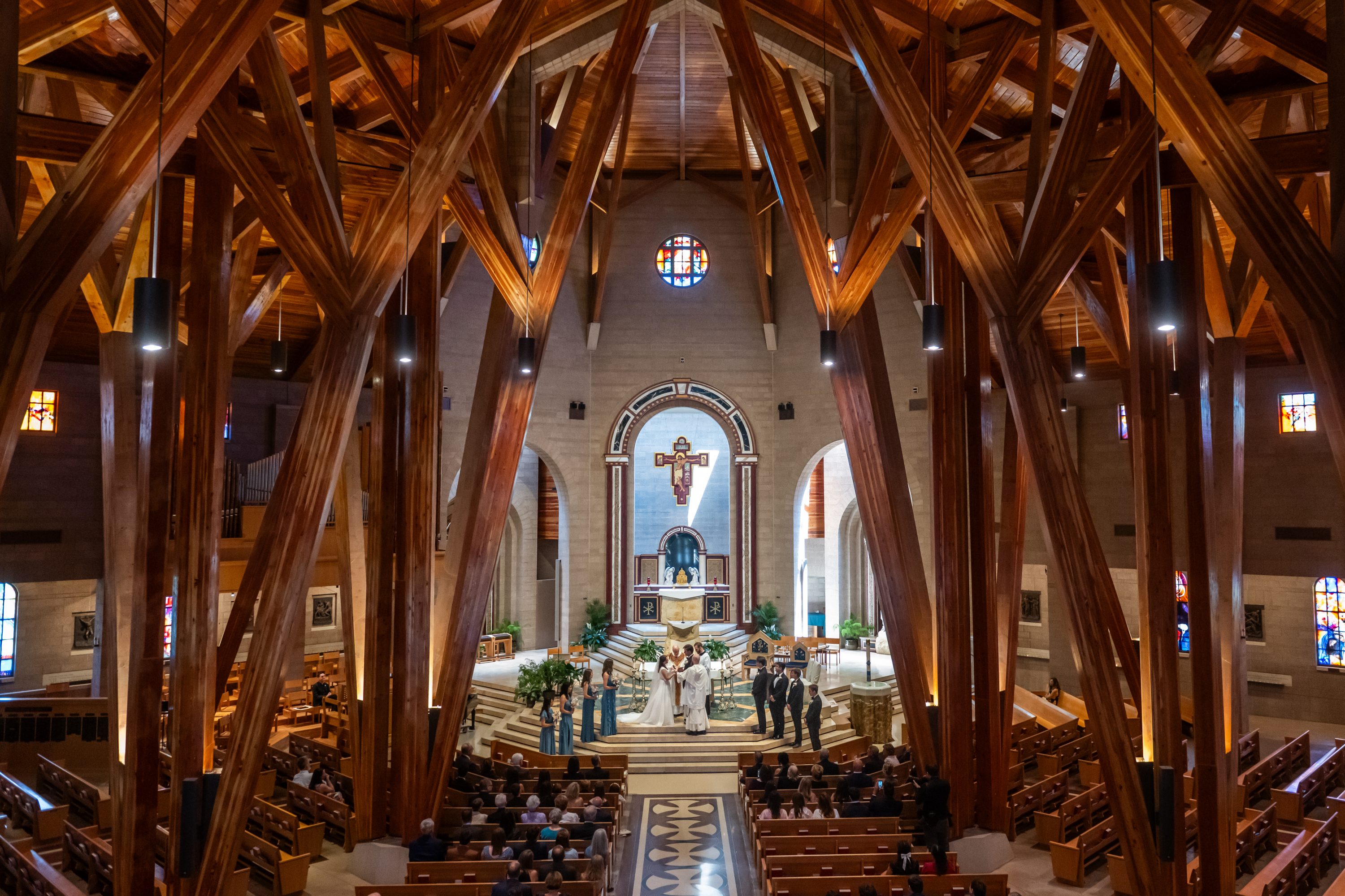 A balcony view of Our Lady of Loreto Church in Aurora, Colorado, showing the beams of red- and brown-colored wood of the sanctuary.